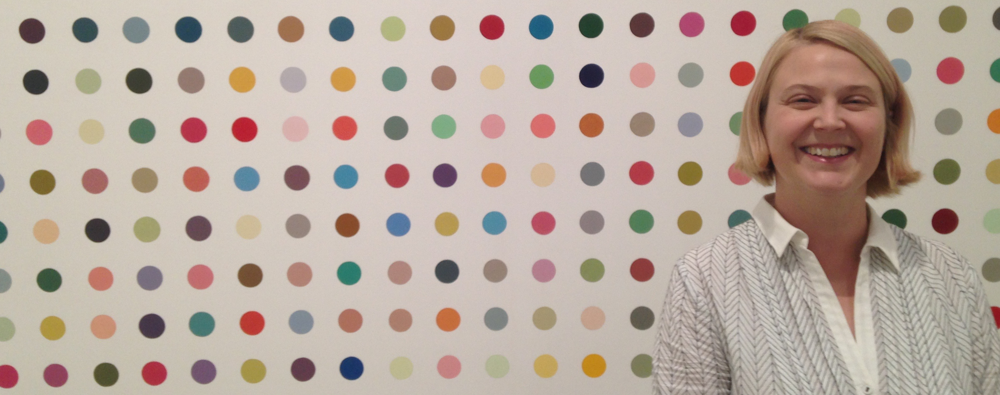 Ginny Pennekamp in front of a Herst painting